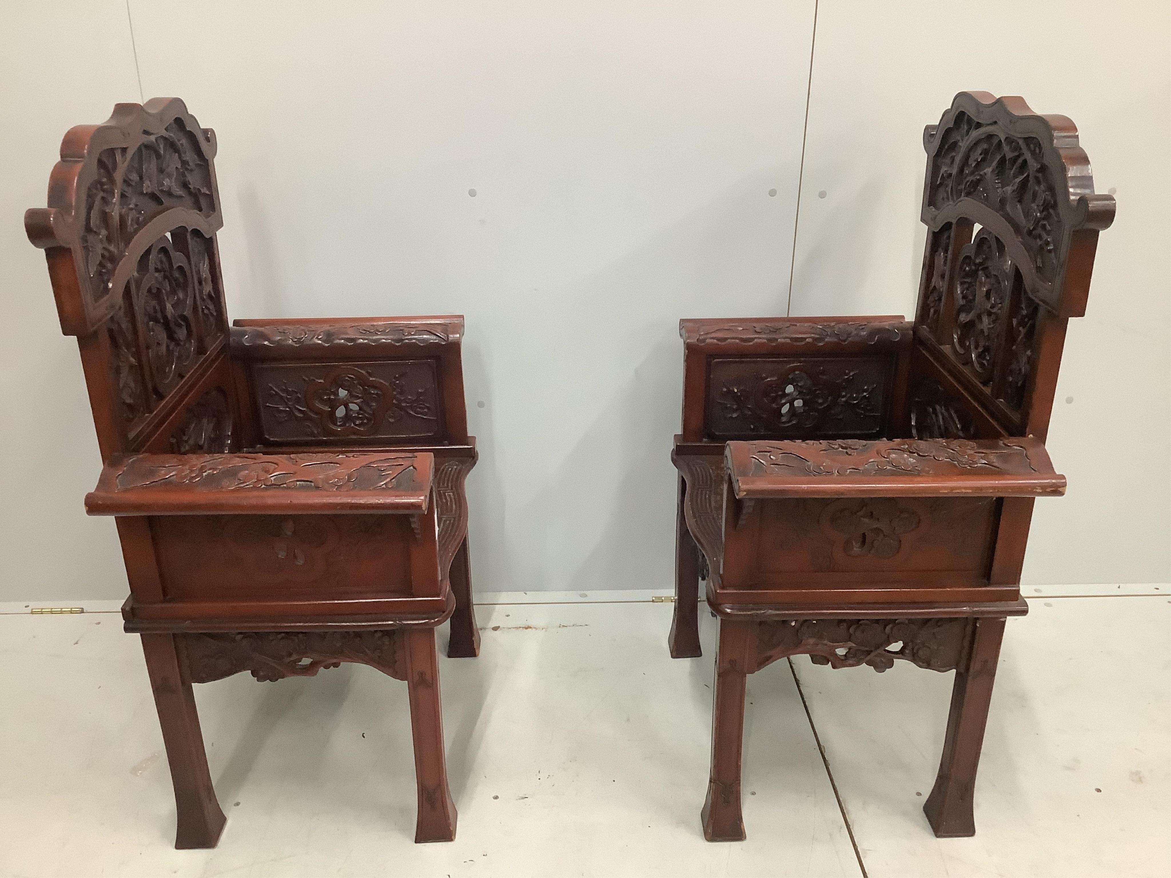 A pair of Chinese carved hardwood armchairs, width 73cm, height 111cm. Condition - rather worn in places
